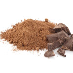 Ground cocoa pile and chocolate pieces isolated on white background. Predominant color : brown. DSRL studio photo taken with Canon EOS 5D Mk II and EF100mm f/2.8L Macro IS USM